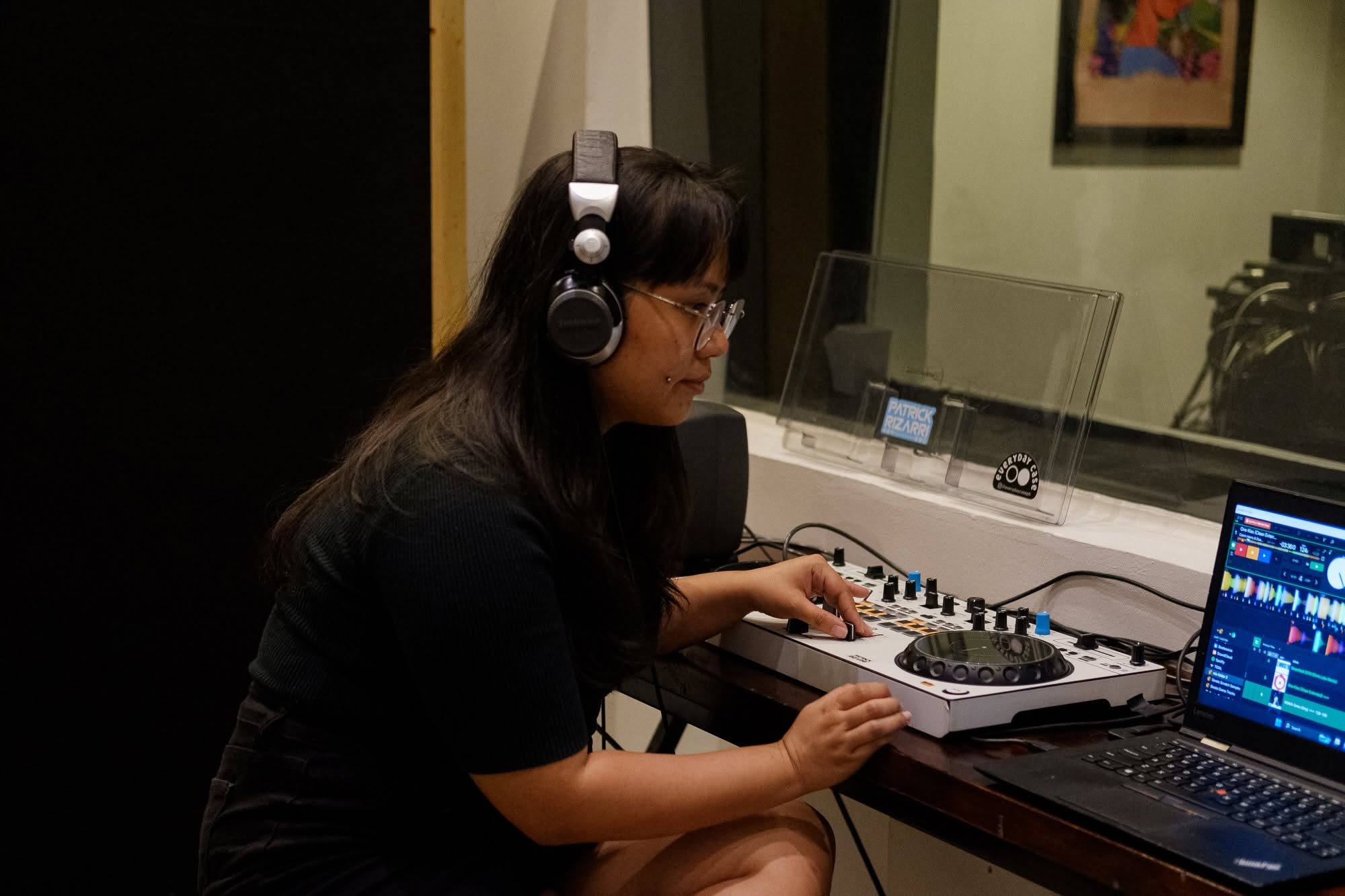 Student wearing headphones in recording booth